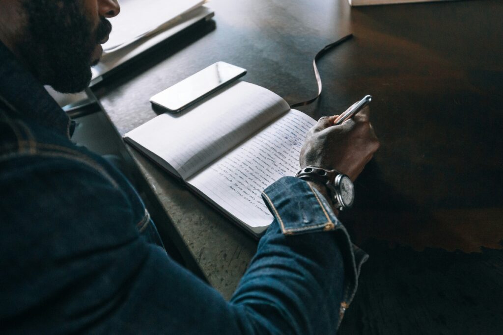man writing in book